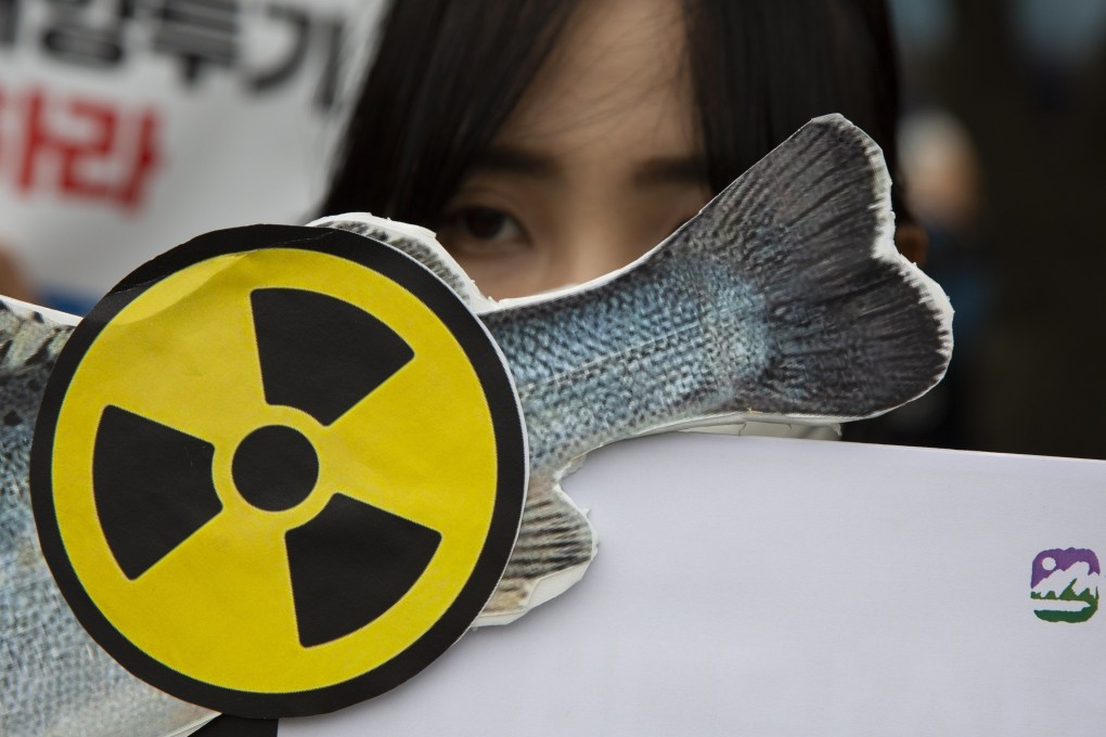 Members of environmental groups hold up banners during a rally against Japan’s disposal of radioactive water on June 8, 2023. Photo: EPA-EFE