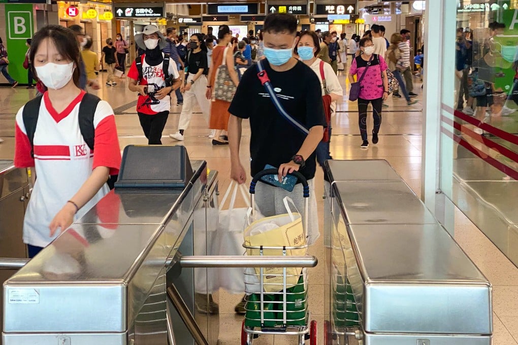 “Daigou” courier Ye Qingren (centre) passes through an MTR station on the way to meeting one of his customers. Photo: Fiona Sun