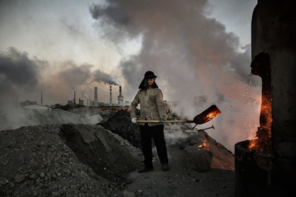 INNER MONGOLIA, CHINA - NOVEMBER 03: A Chinese labourer loads coal into a furnace as smoke and steam rises from an unauthorized steel factory on November 3, 2016 in Inner Mongolia, China.Photo:Getty Images