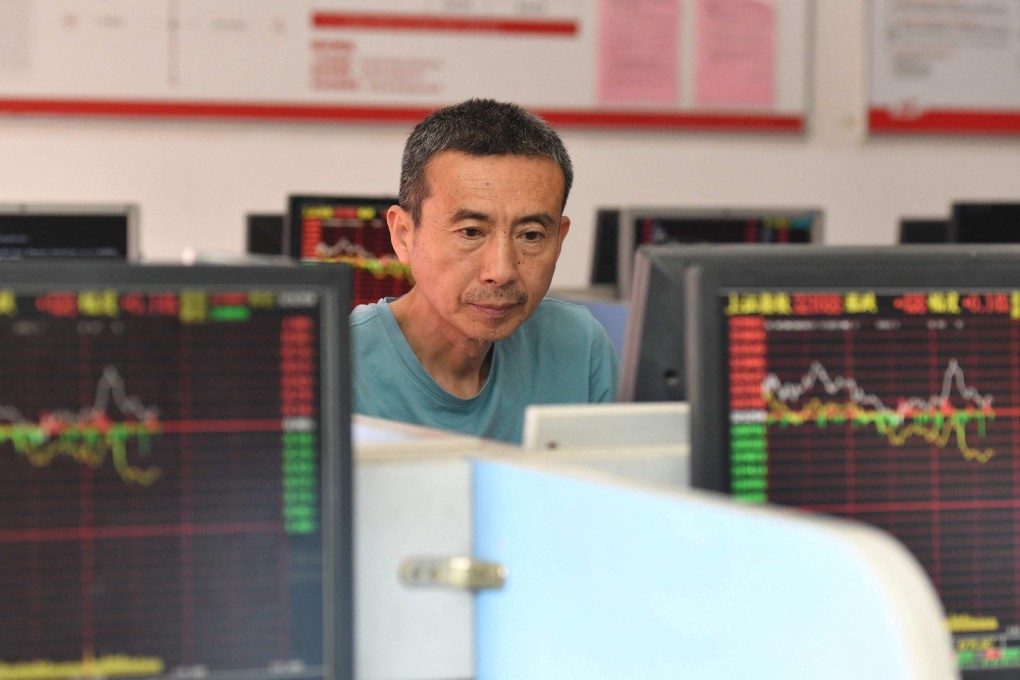 An investor looks at screens showing stock market movements at a securities company in Fuyang, Anhui province, on May 29. With the property market in distress, Chinese money is stuck in bank deposits, instead of finding its way into the real economy. Beijing could consider redirecting household wealth from property to the equity market. Photo: AFP