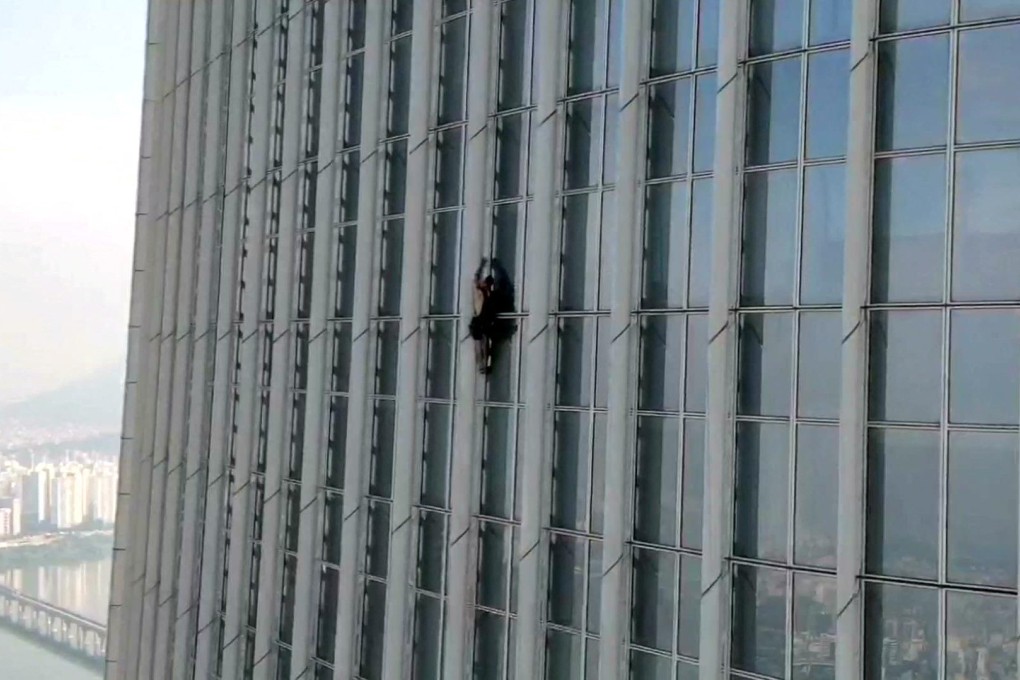 A British man climbs South Korea’s tallest building, the 123-storey Lotte World Tower in Seoul, without a rope before being forced to abandon his climb more than halfway up on Monday. Photo: South Korea’s Songpa Fire Station/Handout via Reuters