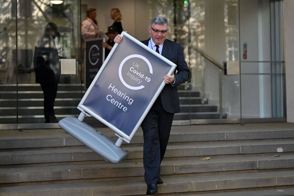 A person sets out a sign outside the venue for the UK Covid-19 Inquiry, which is probing the UK government’s handling of the coronavirus pandemic. Photo: AFP