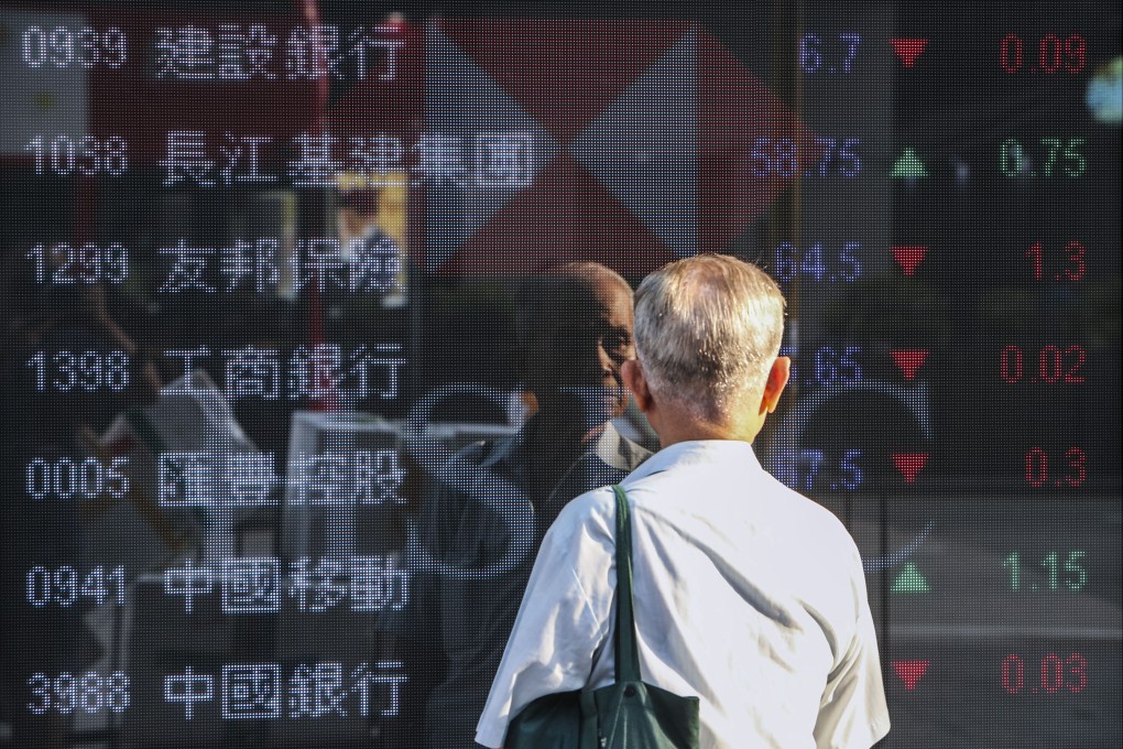 A man looks at prices of Hang Seng Index members outside a bank in Mong Kok, Hong Kong. Photo: Winson Wong