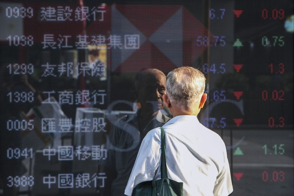 A man looks at prices of Hang Seng Index members outside a bank in Mong Kok, Hong Kong. Photo: Winson Wong