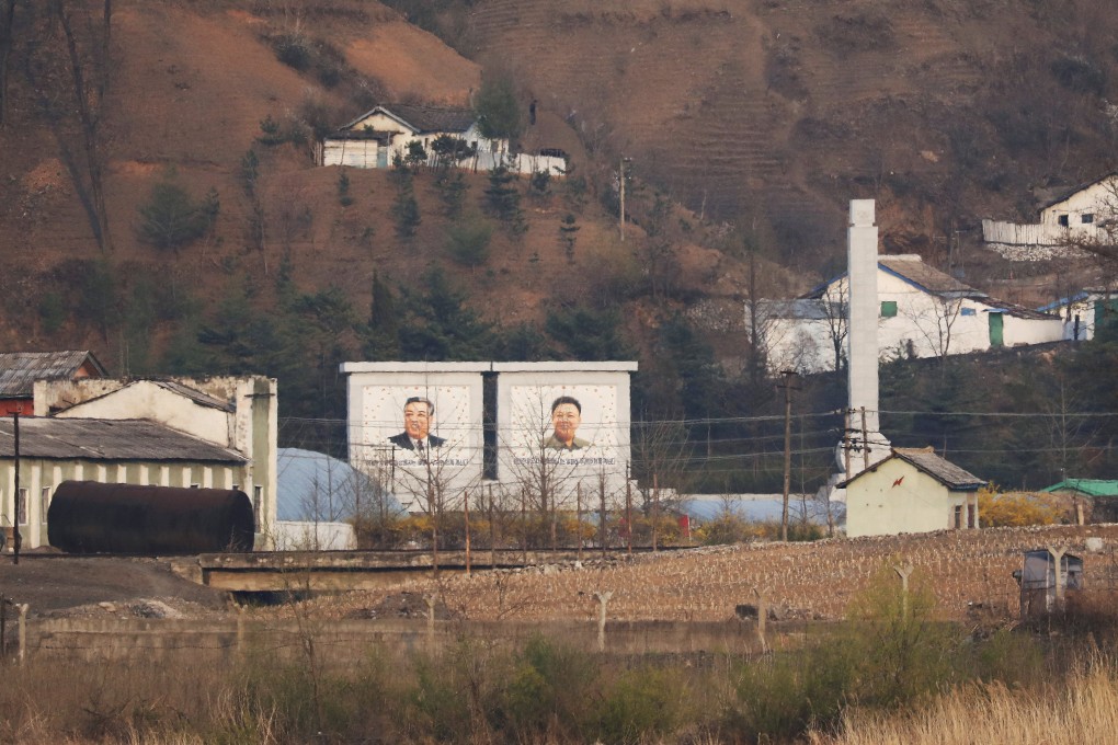 Giant portraits of the late North Korean leaders Kim Il-sung and Kim Jong-il are seen from the Chinese border city of Dandong, Liaoning province. Photo: Reuters