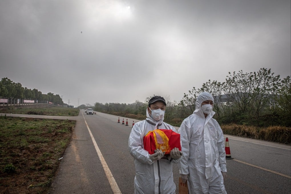 A man carries a box containing cremated ashes near a funeral house in Wuhan, China during the early days of the coronavirus outbreak in April 2020. Photo: EPA-EFE