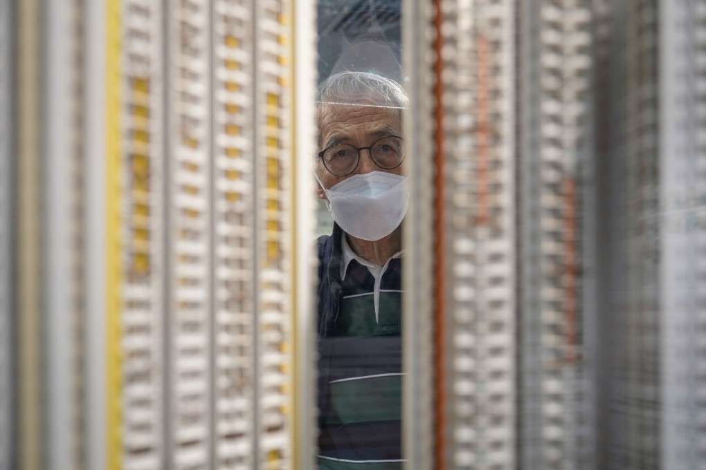 A man looks at models of Home Ownership Scheme buildings at the Housing Authority office in Kwun Tong on March 28. Photo: Sam Tsang