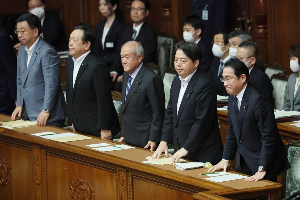 Japan’s Prime Minister Fumio Kishida, right, and his cabinet members react after the no-confidence motion was rejected at the plenary session of the House of Representatives in Tokyo. Photo: AFP