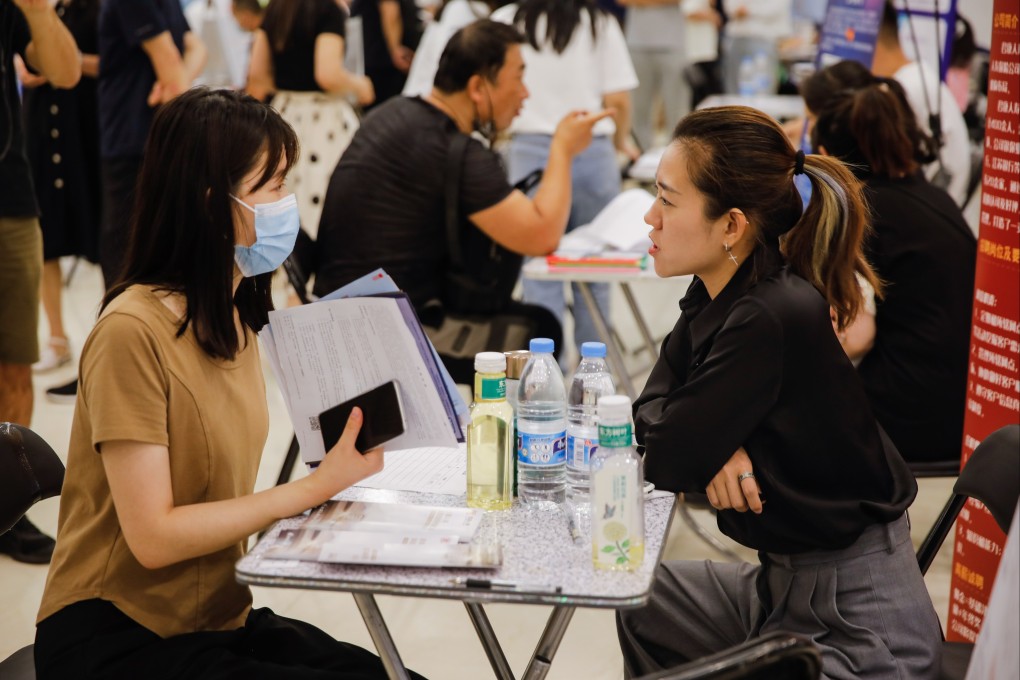 A jobseeker interacts with a recruiter at a job fair in Beijing on June 9. Photo: EPA-EFE