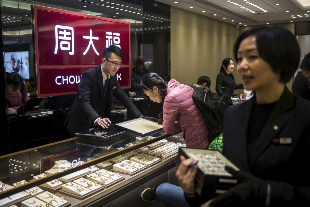 Employees serve customers in a Chow Tai Fook jewellery store. Photo: Bloomberg