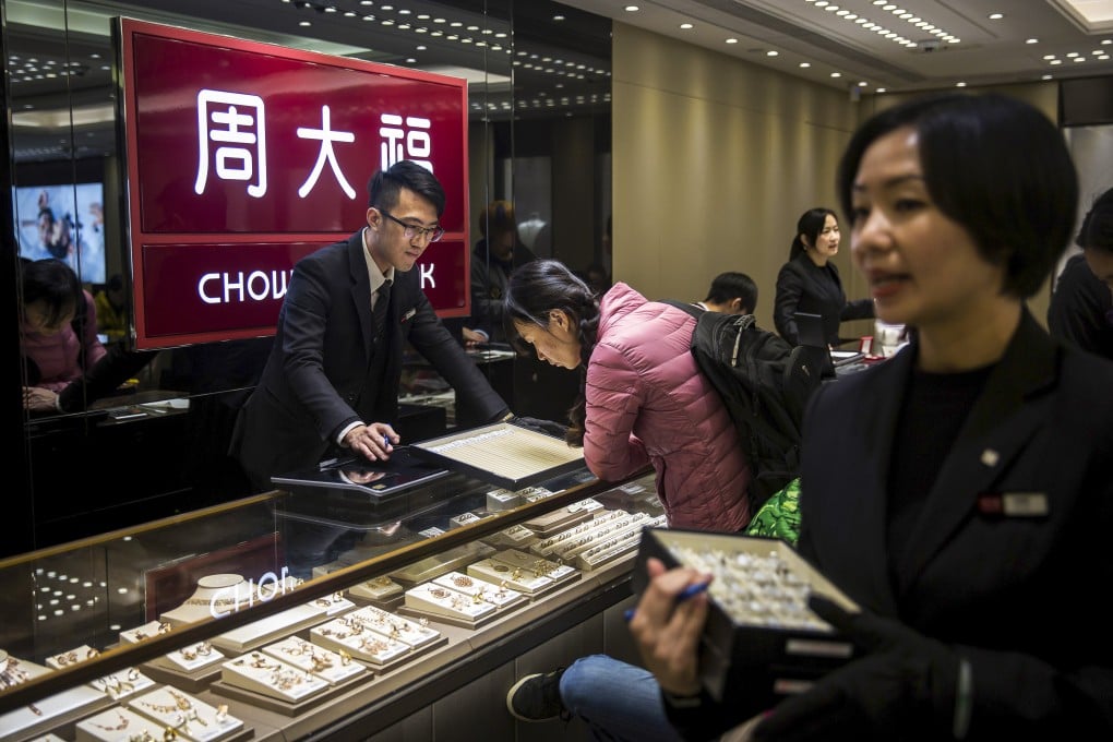 Employees serve customers in a Chow Tai Fook jewellery store. Photo: Bloomberg