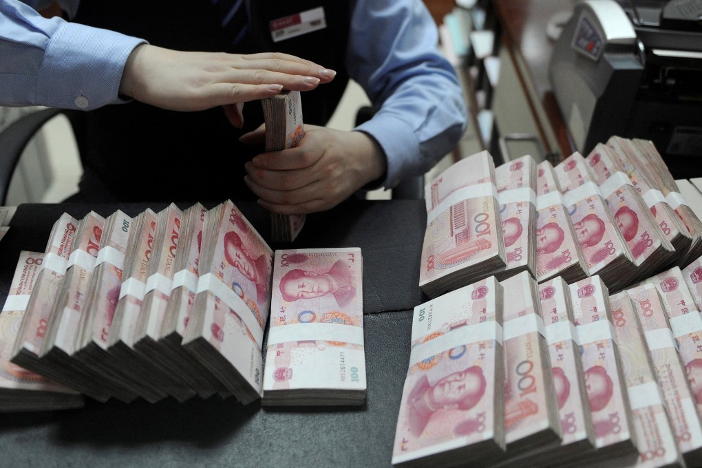 An employee counts 100 yuan notes at a bank in Hefei, Anhui province. The growing spread between US and Chinese government bond yields is one of several factors driving the prospect of a weaker yuan. Photo: Reuters