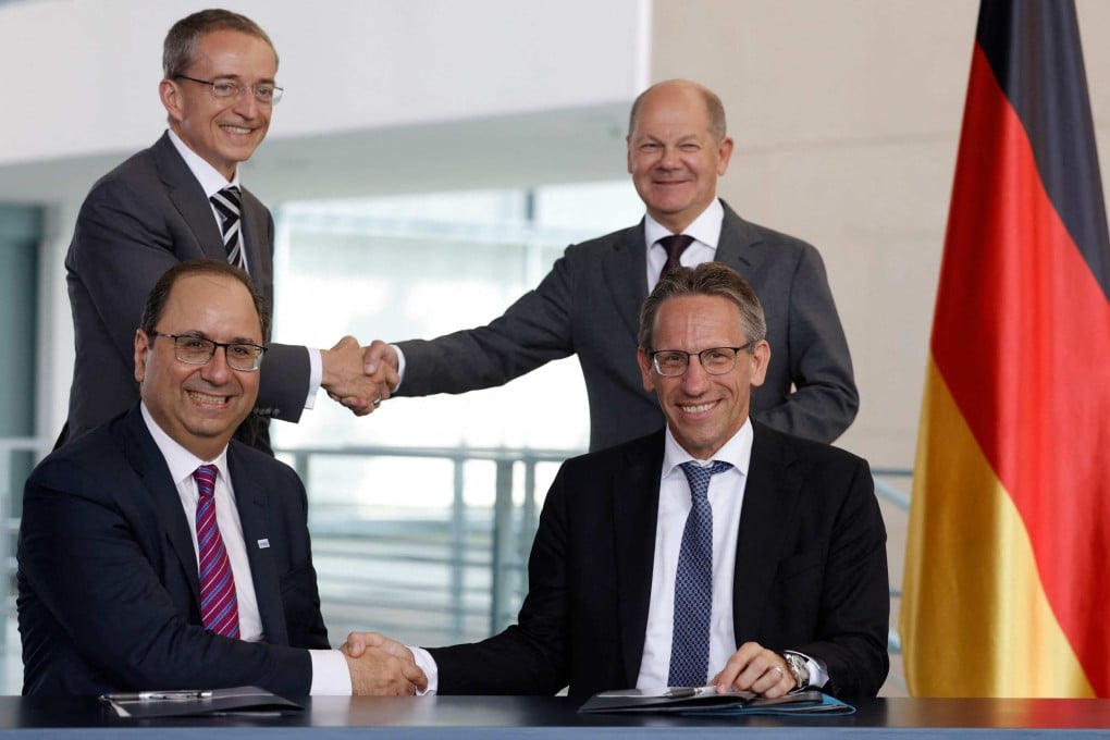 German Chancellor Olaf Scholz (background, right) shakes hands with Pat Gelsinger (background, left), CEO of US multinational corporation and technology company Intel, as State Secretary at the Chancellery Joerg Kukies (foreground, right) and Intel executive vice-president Keyvan Esfarjani (foreground, left) also shake hands after signing an agreement between the German government and Intel on June 19, 2023 at the Chancellery in Berlin. Photo: AFP