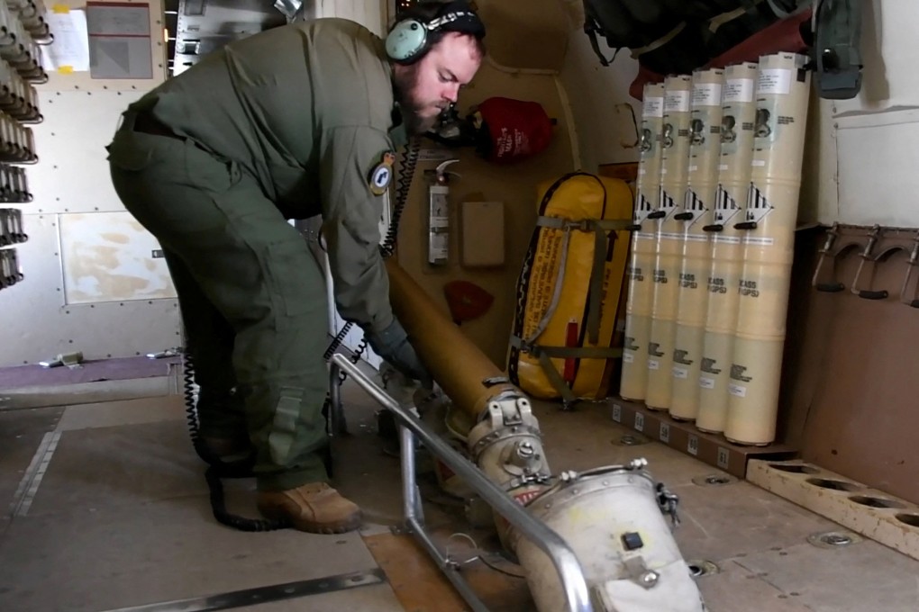 A crew member of a Royal Canadian Air Force CP-140 Aurora maritime surveillance aircraft drops sonar buoys as the plane flies a search pattern for the missing OceanGate submersible on Tuesday. Photo: Canadian Forces via Reuters