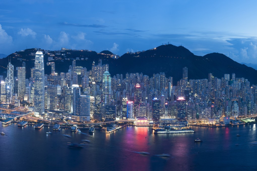 Hong Kong’s iconic skyline as seen at dusk, with skyscrapers lit up against a mountainous backdrop. Photo: Shutterstock