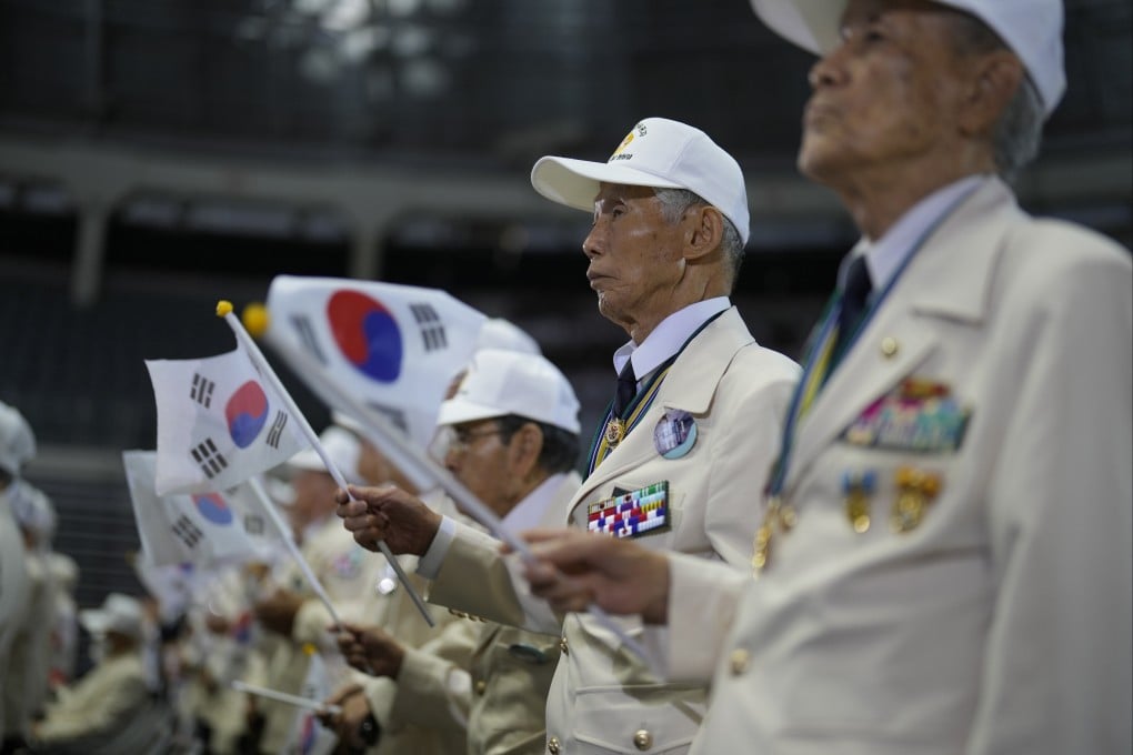 War veterans wave national flags during a ceremony marking the 73rd anniversary of the outbreak of the Korean war, in Seoul, South Korea on Sunday. Photo: AP