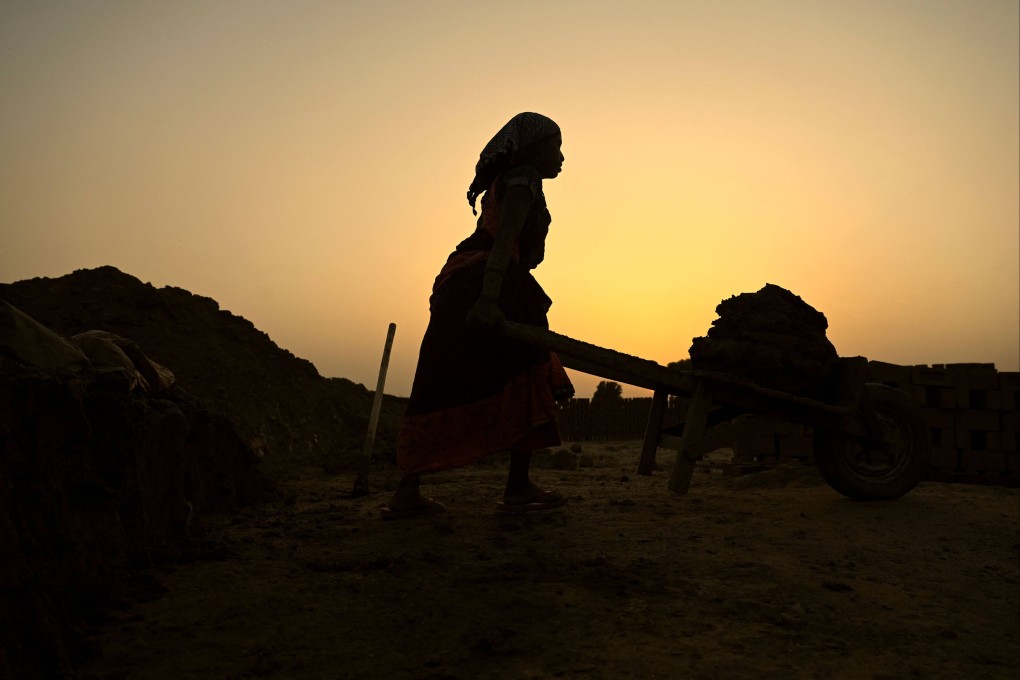 A labourer transports raw material used for moulding brick on the outskirts of Jalandhar in India’s Punjab state. Photo: AFP