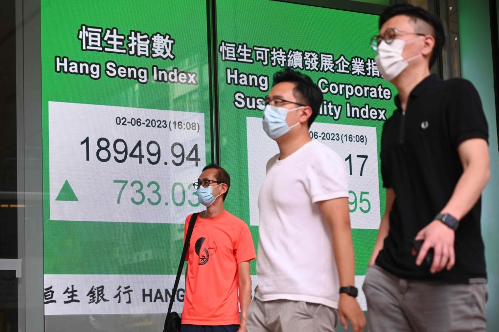 Pedestrians walk past a sign showing the Hang Seng Index outside a bank on June 2. Photo:AFP