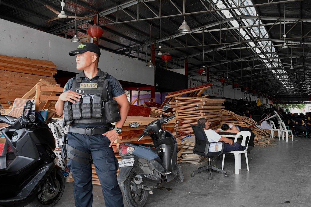 A policeman stands guard inside a compound in Las Pinas city, Metro Manila, following Tuesday’s massive nighttime raid. Photo: AFP