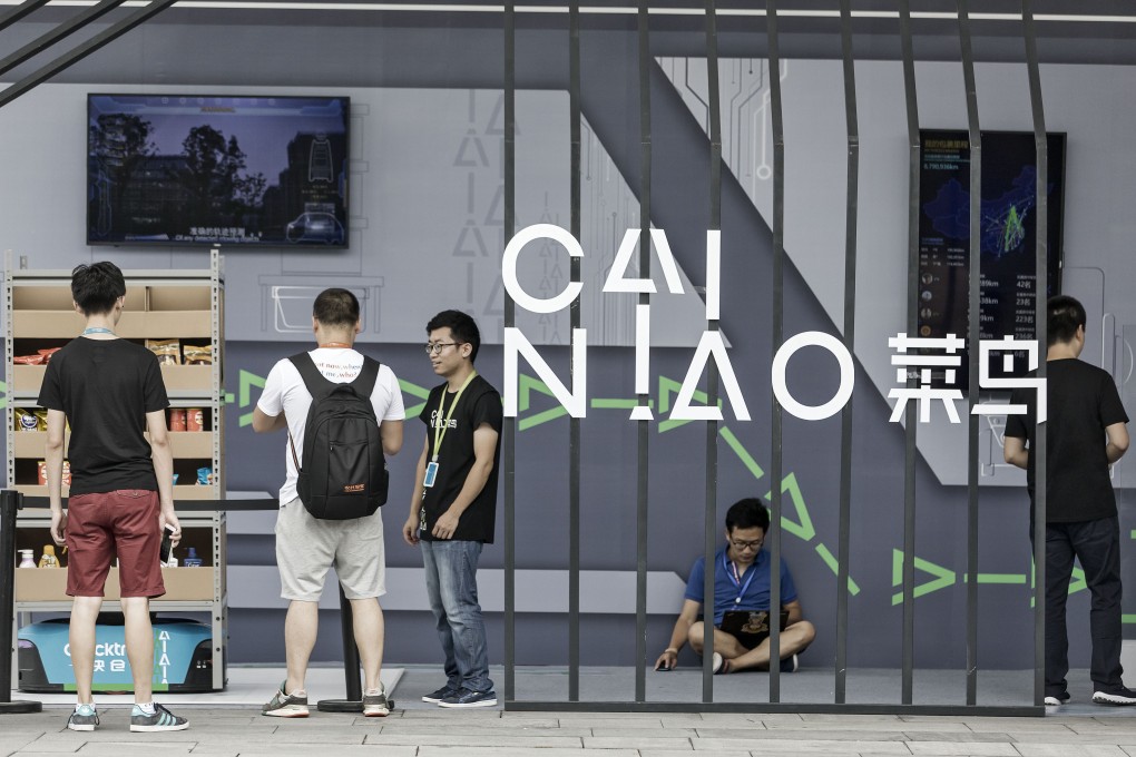 Employees and visitors stand near the Cainiao display at the Alibaba headquarters in Hangzhou, China, Sept. 8, 2017. Photo: Bloomberg