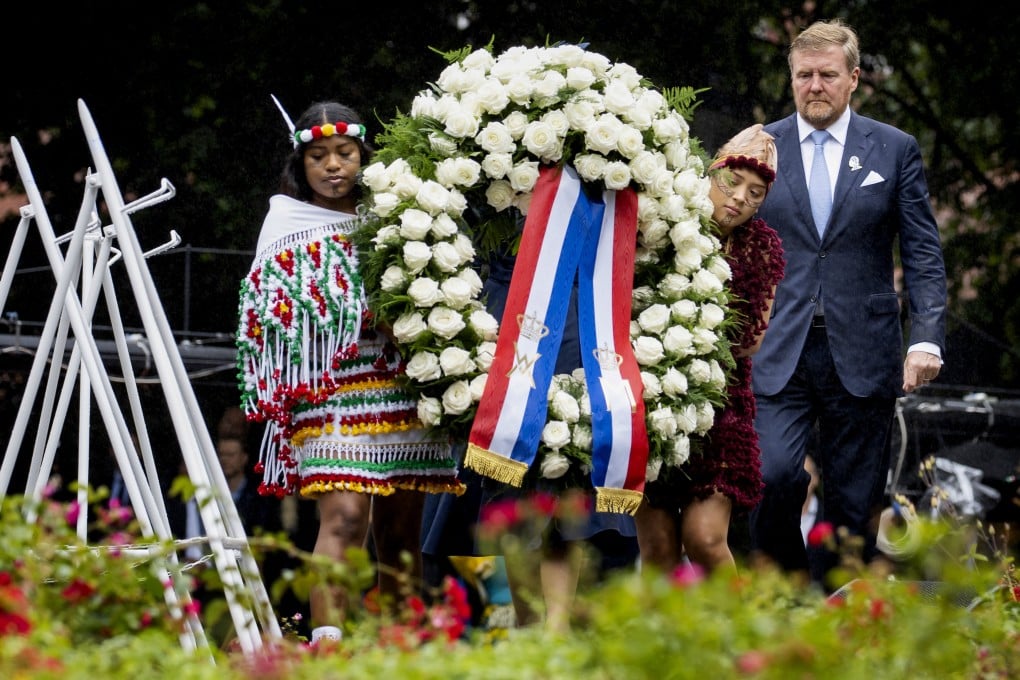Dutch King Willem-Alexander lays a wreath at the slavery monument after apologising for the royal house’s role in slavery, in Amsterdam, Netherlands on Saturday. Photo: Pool Photo via AP