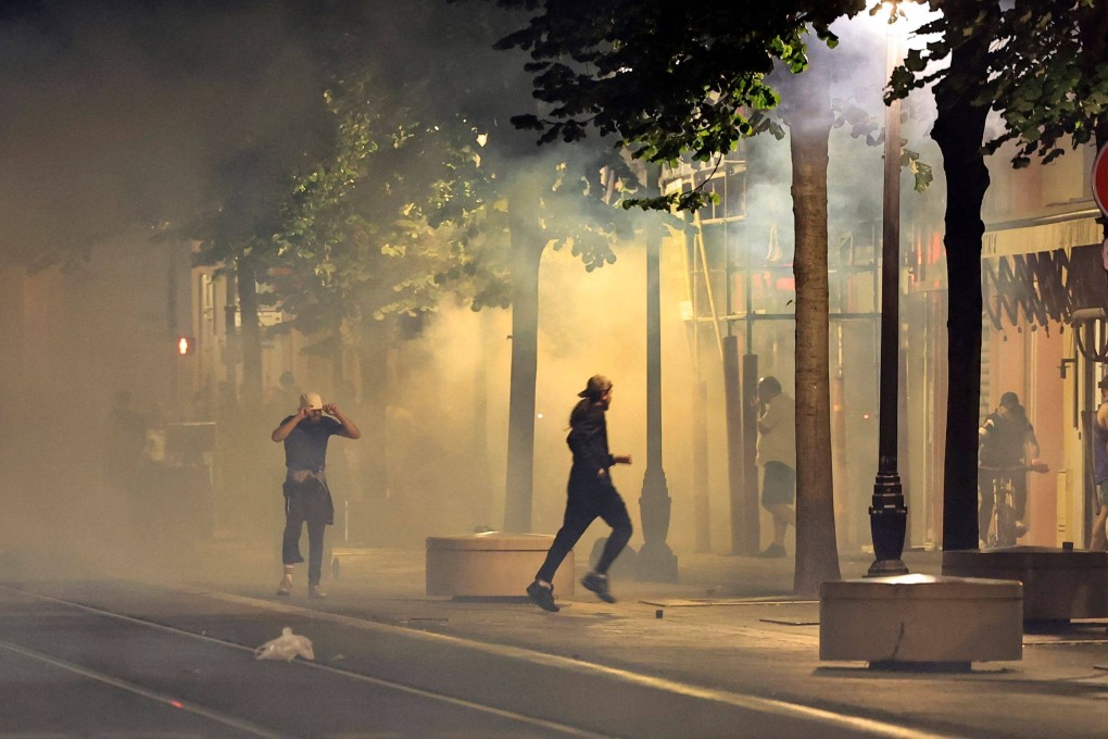 Protesters flee from smoke on a street in Nice, southeastern France, in the early hours of Sunday during the fifth night of rioting following the fatal shooting of a teenager in a Paris suburb on June 27. Photo: AFP