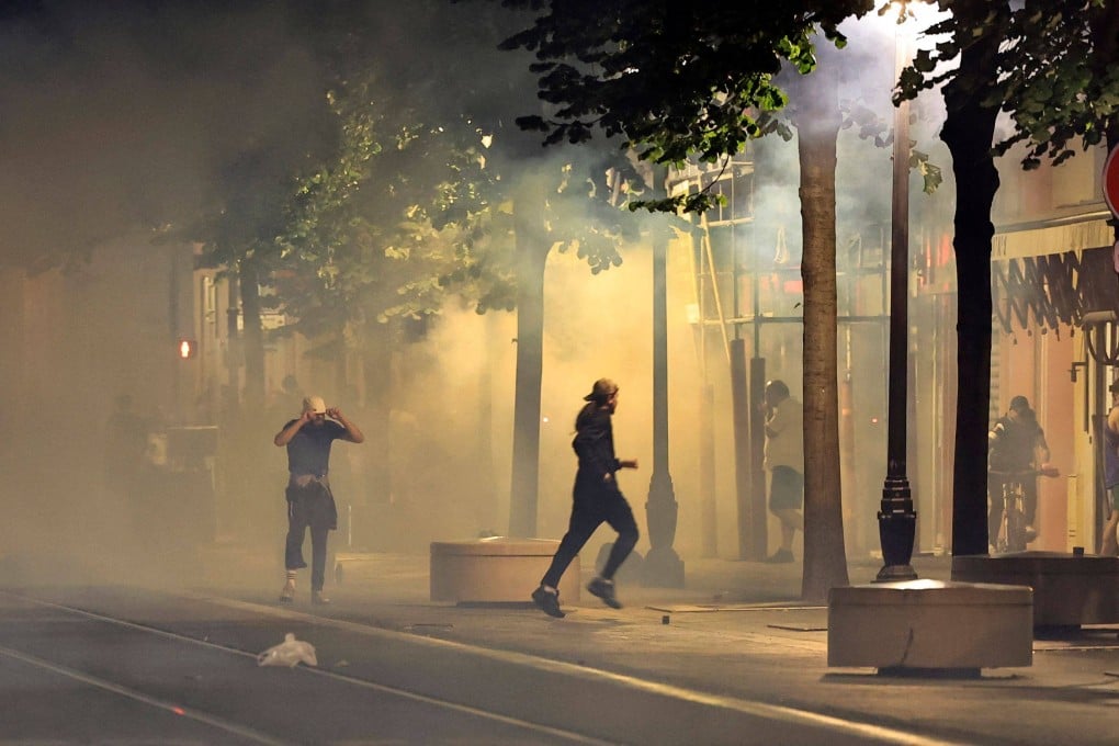 Protesters flee from smoke on a street in Nice, southeastern France, in the early hours of Sunday during the fifth night of rioting following the fatal shooting of a teenager in a Paris suburb on June 27. Photo: AFP