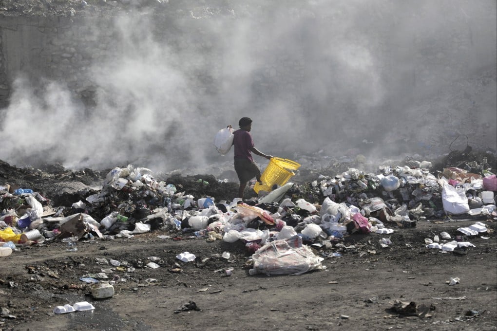 A woman walks through a landfill looking for salvageable items, in Port-au-Prince, Haiti, on Saturday. Photo: AP
