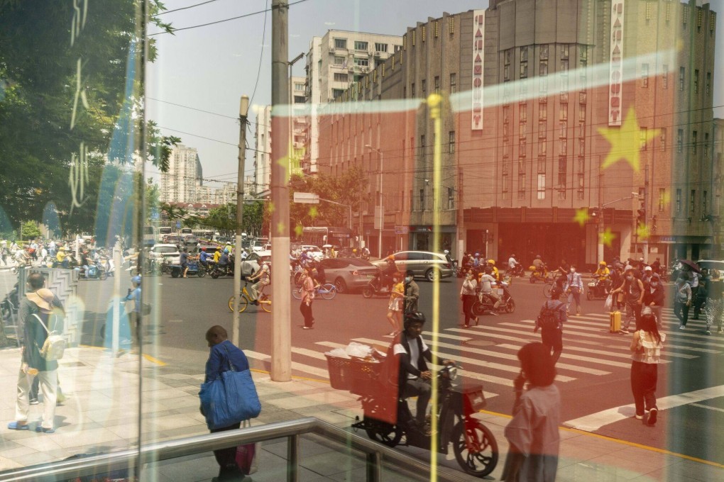 Chinese flags reflected in a window in Shanghai. Photo: Bloomberg