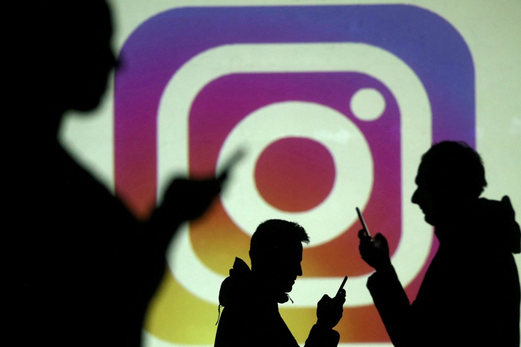 Silhouettes of smartphone users are seen next to a screen projection of the Instagram logo in this picture illustration. Photo: Reuters