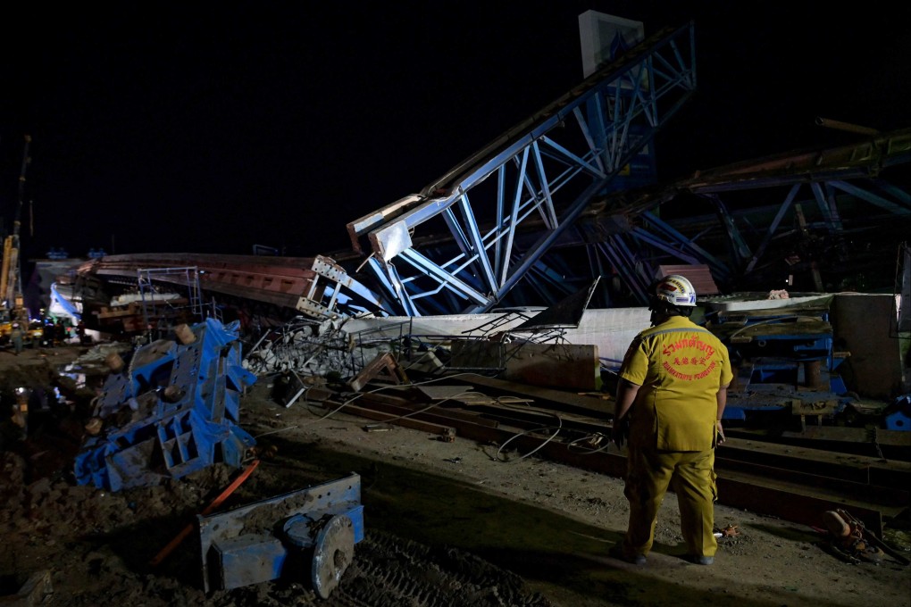 A rescue worker inspects the scene after a construction girder collapsed on a road in Bangkok. Photo: AFP