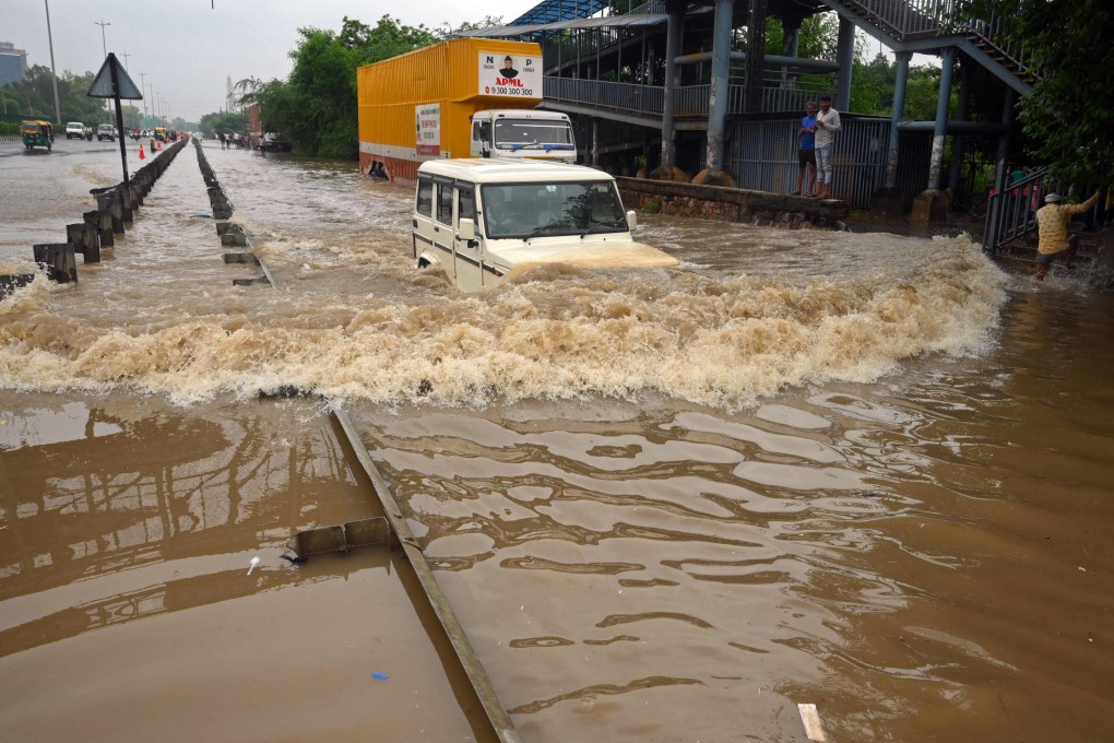 A motorist drives through a flooded highway on the outskirts of Indian capital New Delhi after heavy monsoon rains on Sunday. Photo: AFP