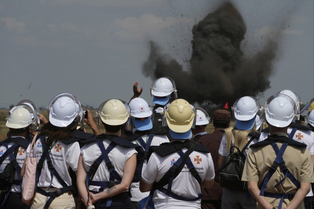 Ukrainian deminers view a controlled explosion during a visit to a mine field in Cambodia’s Battambang province in January. Around 20,000 Cambodians have been killed over the last four decades after stepping on landmines or unexploded ordnance. Photo AP