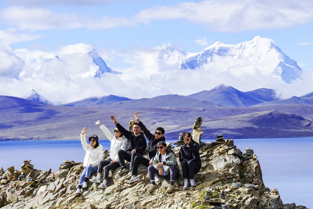 Chinese tourists pose for photos by Lake Puma Yumco in Tibet this month. Only 1.6 per cent of Chinese travelling in tour groups went overseas in the first quarter of this year, down from 30 per cent from the same period in 2019, according to official figures. Photo: Xinhua