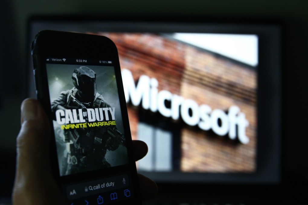 Activision’s Call of Duty on a smartphone near a photograph of the Microsoft logo. Photo: AP