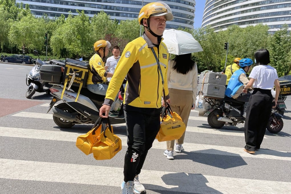 A Meituan delivery man carries online ordered lunches in Beijing. The company is among those that were fined and saw restructuring amid Beijing’s regulatory crackdown. Photo: Simon Song