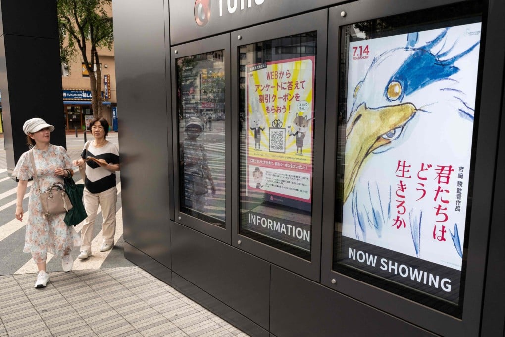 Women look at a display in Tokyo showing a poster (above, right) for Oscar-winning animator Hayao Miyazaki’s latest film, “How Do You Live?”, on the first day of its screening in cinemas in Japan. The film, his first in a decade, may also be his last. Photo: AFP