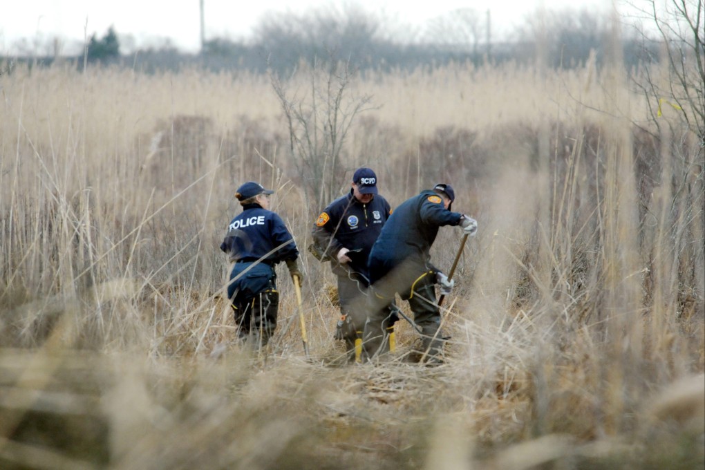 Crime scene investigators use metal detectors to search a marsh for human remains on Oak Beach, New York, in December 2011. Photo: Newsday via AP