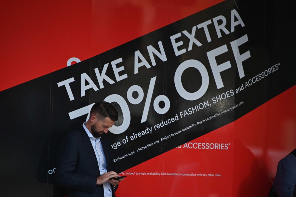 A man uses his phone outside a department store in Sydney in June 2019. An Australian senate select committee is looking into the potential for foreign interference in Australian politics through social media. Photo: AFP