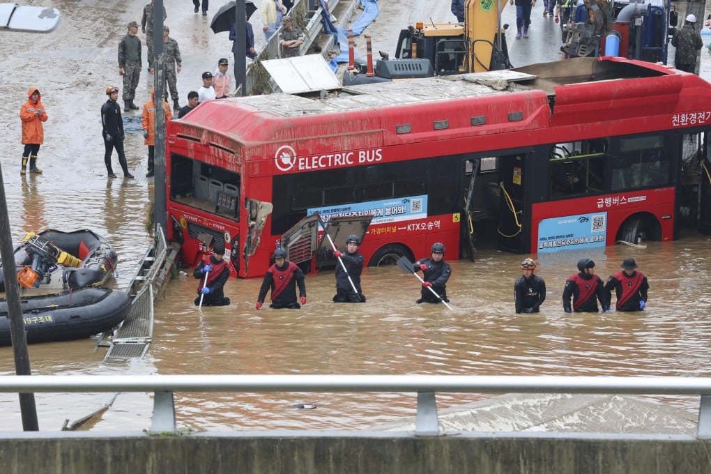 Rescuers search for survivors along a road submerged by floodwaters in Cheongju, South Korea. Photo: Yonhap via AP