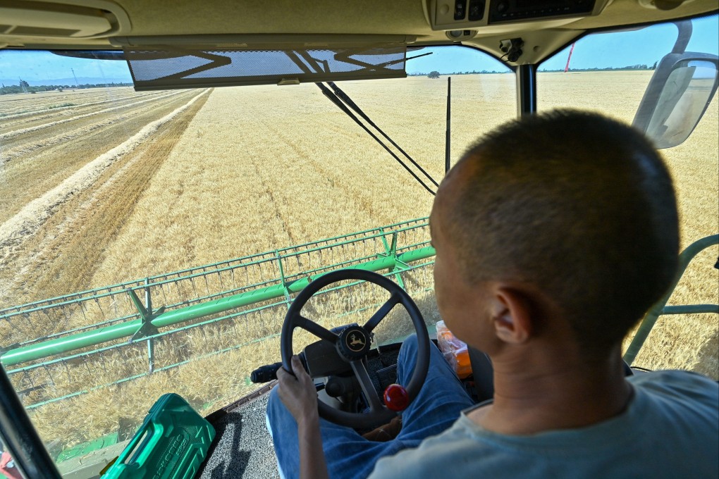 A farmer harvests wheat on Saturday in China’s Xinjiang Uygur autonomous region. Photo: Xinhua