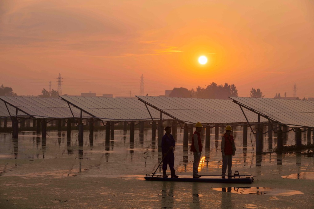 Workers inspect solar panels at the fishing-solar complementary photovoltaic power generation base in Taizhou, in China’s eastern Jiangsu province, on July 12, 2023. Photo: AFP