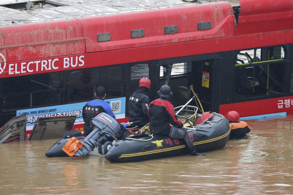 Rescuers conduct a search operation along a road submerged by floodwaters leading to an underground tunnel in Cheongju, South Korea. Photo: Yonhap via AP