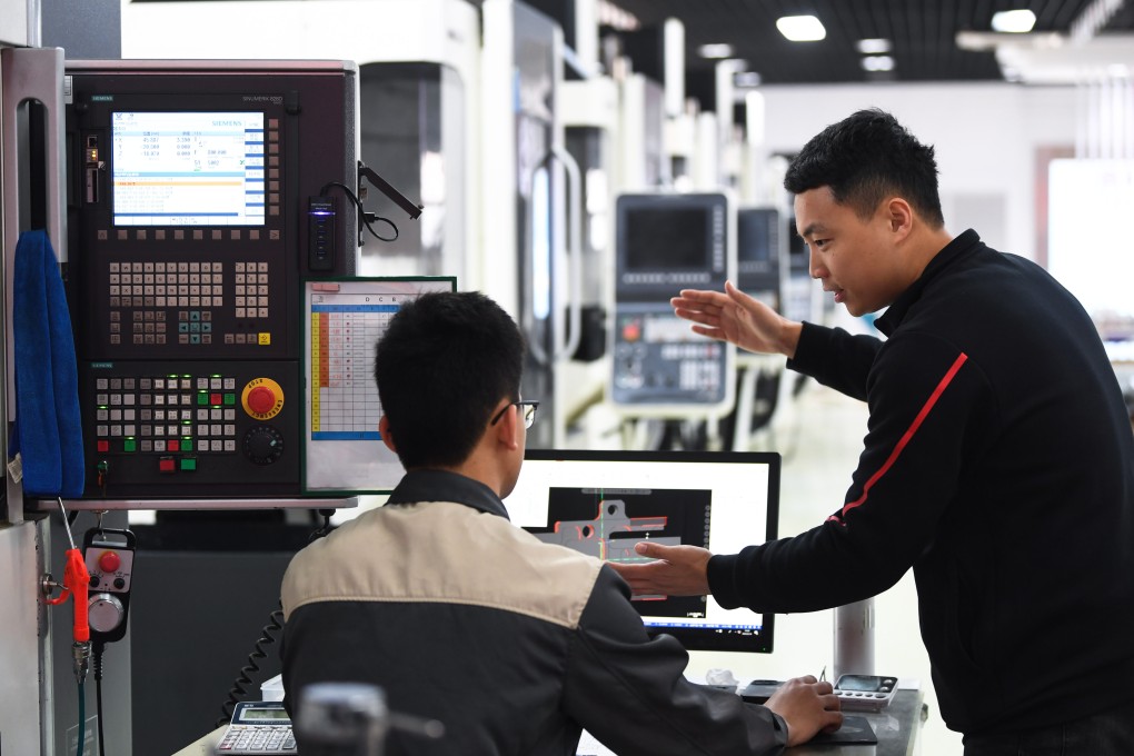 A vocational trainer (right) teaches a student how to operate a machine tool at a technical college in China’s Guangdong province. Photo: Xinhua