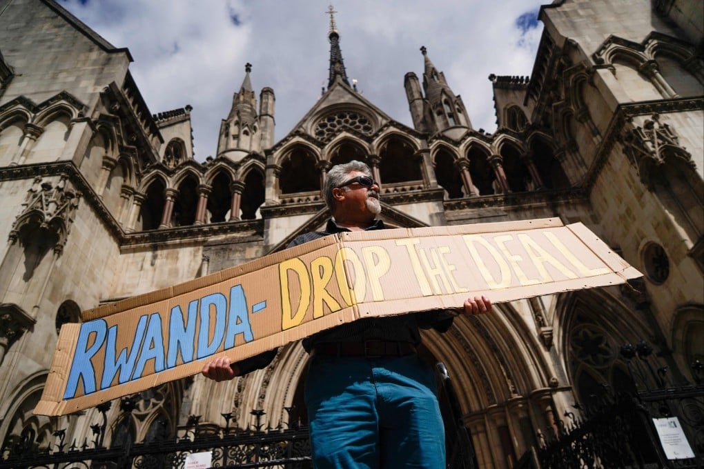 A demonstrator holds a placard during a protest against Britain’s Rwanda asylum plan outside the High Court in London in June 2022. Photo: AFP