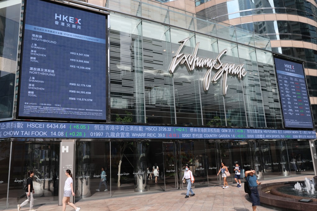People walking past electronic boards displaying the Hang Seng Index and stocks outside the Exchange Square in Central, Hong Kong on June 30. Photo: Yik Yeung-man
