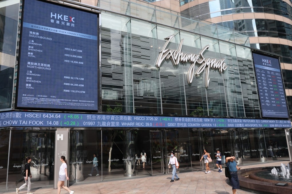 People walking past electronic boards displaying the Hang Seng Index and stocks outside the Exchange Square in Central, Hong Kong on June 30. Photo: Yik Yeung-man