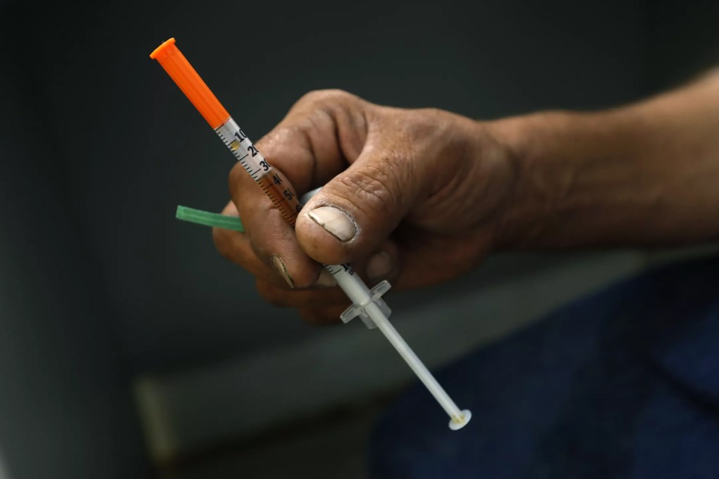 A drug addict holds a syringe containing heroin laced with fentanyl at a safe house in Mexicali, Mexico. Photo: Los Angeles Times/TNS