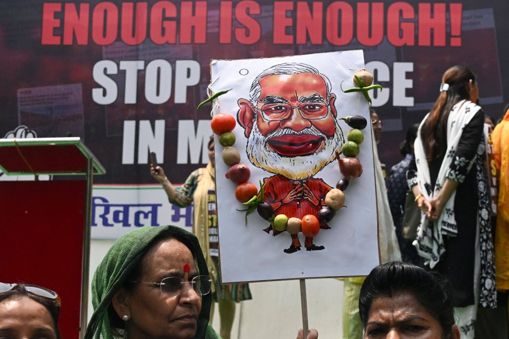 A member of the All India Mahila Congress holds a caricature of PM Modi during a protest over sexual violence against women and for peace in the ongoing ethnic violence in Manipur. Photo: AFP