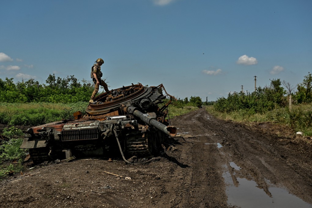 A Ukrainian serviceman inspects a destroyed Russian tank in the recently liberated village of Novodarivka, Zaporizhzhia region, on July 21. Photo: Reuters